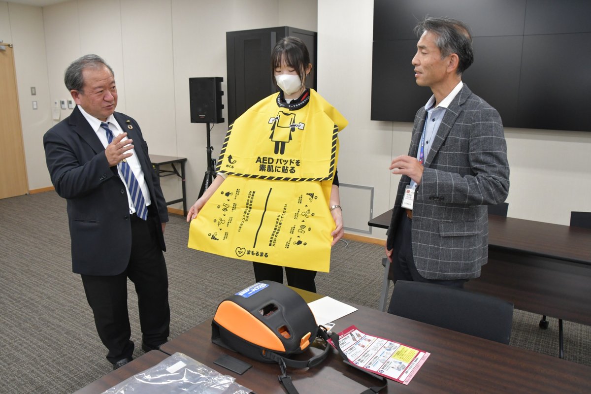 AEDに配備された三角巾を確かめる豊永貞夫議員