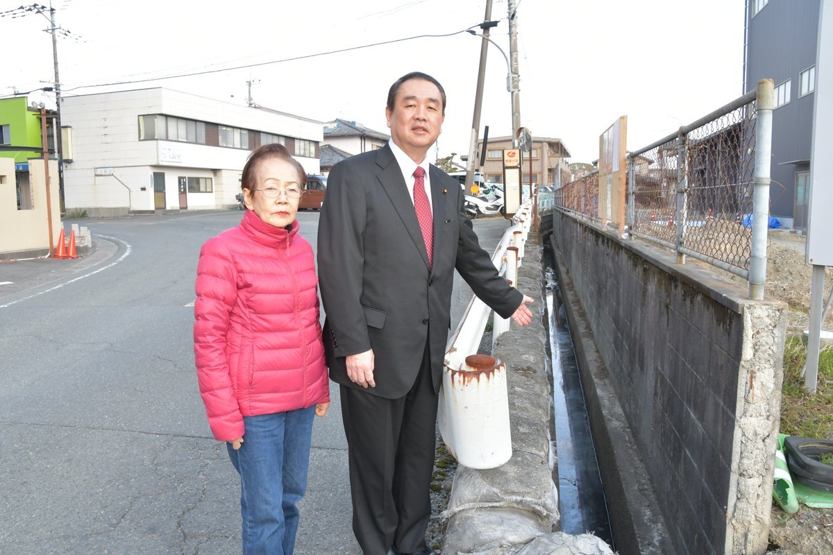 草木が除去された市道脇を住民と確認する浜田大介議員